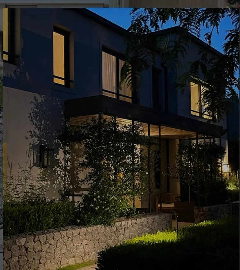 Casa Costa iluminada de noche desde el jardín