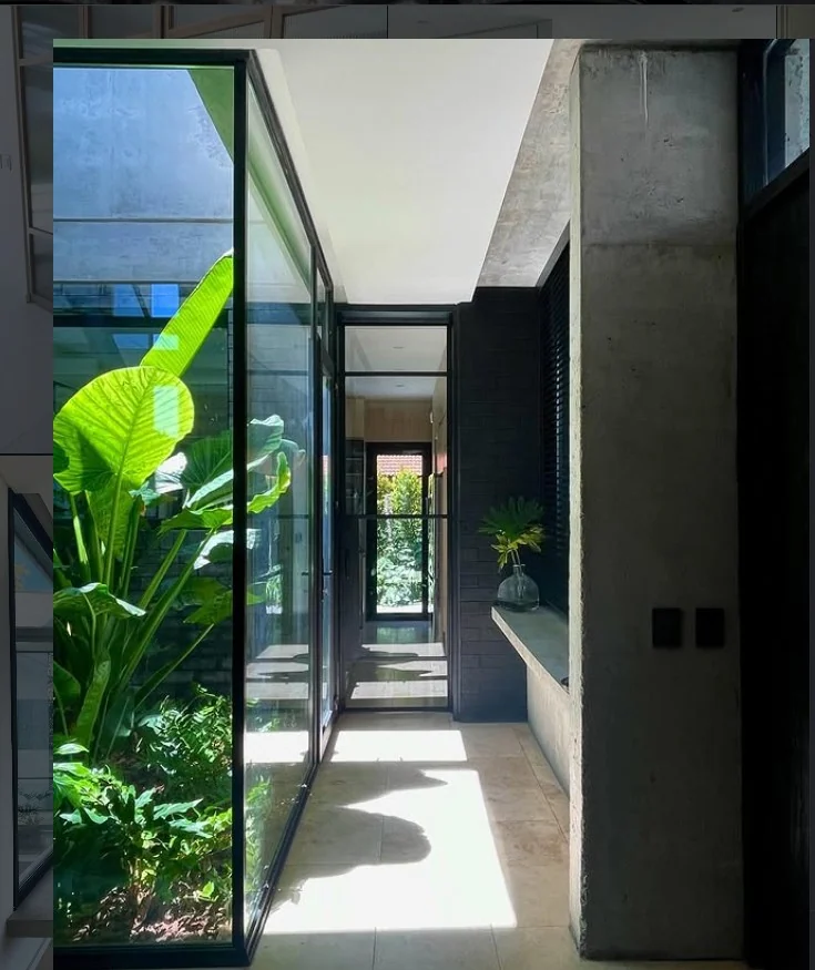Patio interior vidriado de Casa Nordelta visto desde la circulación